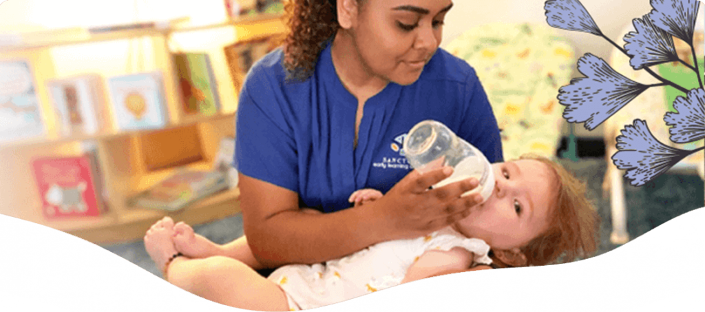 Caretaker giving baby bottled milk — Blog in Ashmore, QLD