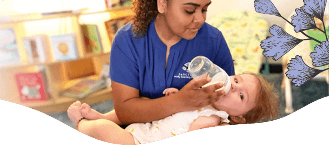Caretaker giving baby bottled milk — Blog in Ashmore, QLD