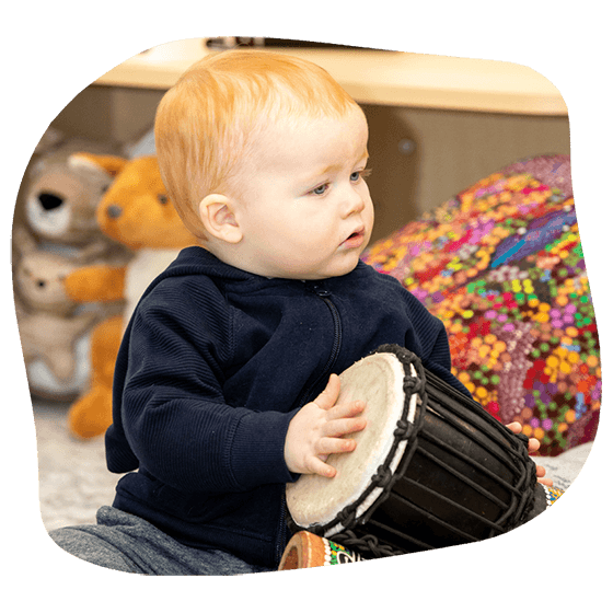 Baby Playing Conga Drum — Early Learning Centre Maudsland,QLD