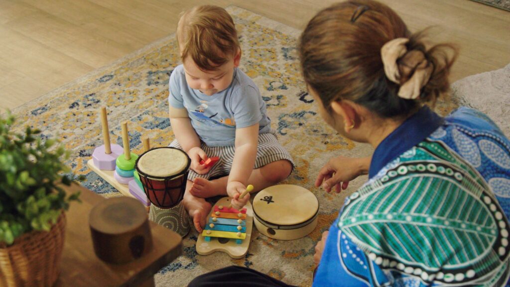 Child playing musical instruments with a Sanctuary Educator