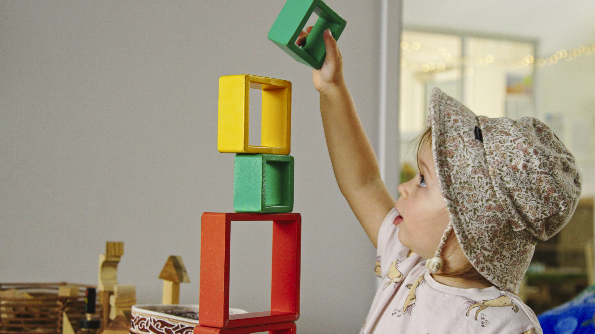 child stacking coloured wooden blocks.
