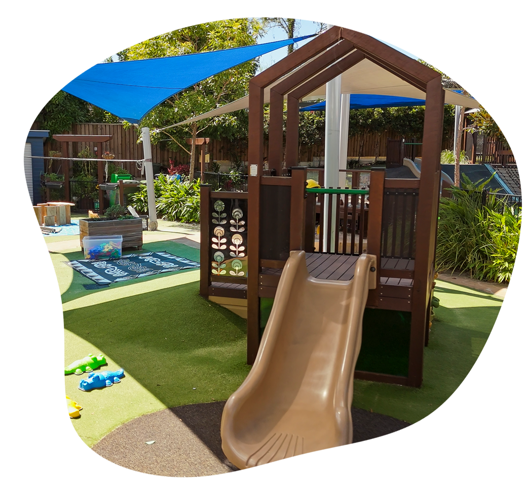 Sanctuary Ashmore's junior playground. A fort with a slide, surrounded by learning opportunities, green space and covered in shade.