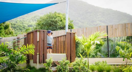 Smiling kid standing on a platform in a garden — Early Learning Centres Near Me in Ashmore, QLD