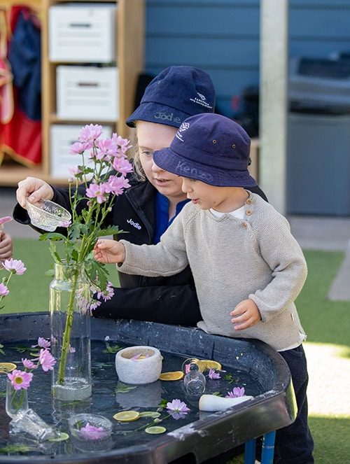 Adult and child enjoying flowers — Early Learning Centre in Buderim, QLD