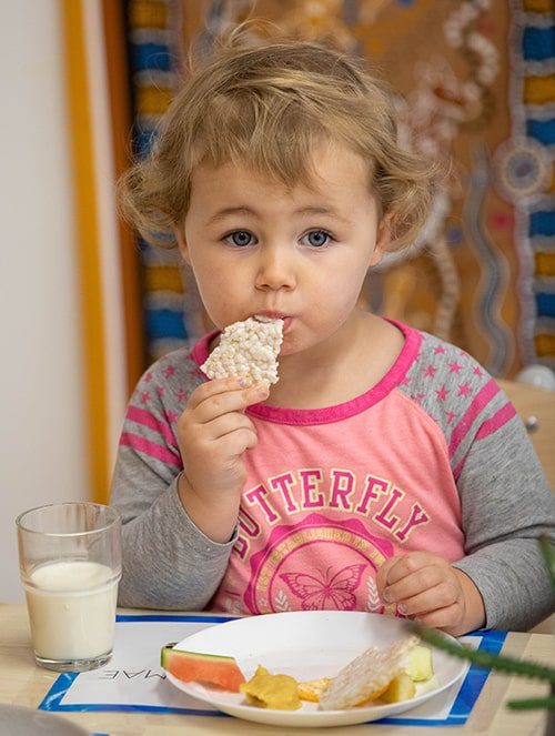 Little girl eating snack — Early Learning Centre in Buderim, QLD