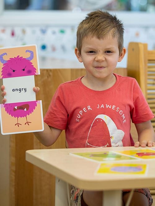 Boy proudly showing card — Early Learning Centre in Buderim, QLD