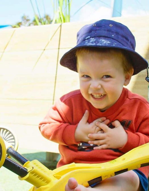 Young Boy Riding a Yellow Scooter — Early Learning Centre Maudsland,QLD