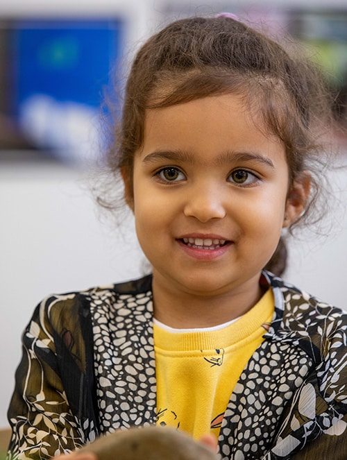 Little girl awkwardly smiling — Early Learning Centre in Maudsland, QLD