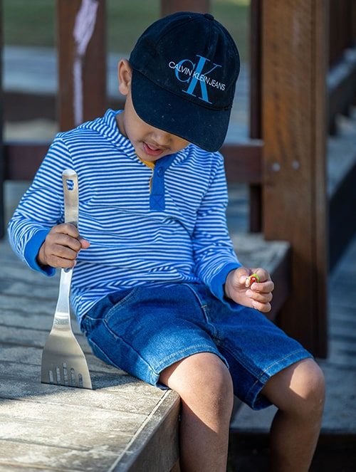 Boy playing with spatula — Early Learning Centre in Maudsland, QLD